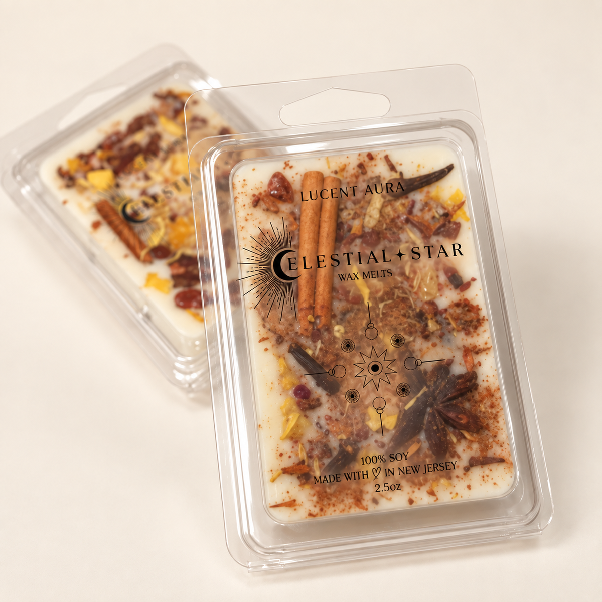 Two clear clamshell packages of wax melts on a white background. The front package shows a white wax base with cinnamon sticks, cocoa powder, citrus pieces, and star anise, labeled 'CELESTIAL STAR' by 'LUENT AURA'.