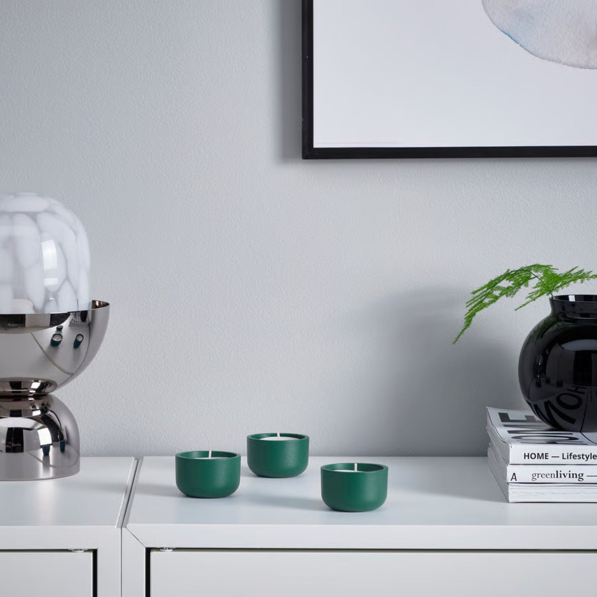 deep turquoise tealight candle holders with a white surface with a modern interior design background.