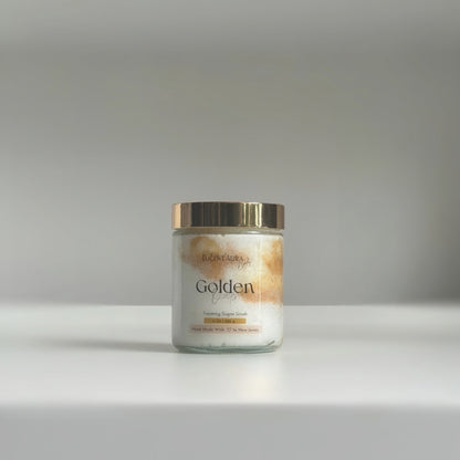 Jar of Golden Oats Sugar Scrub with a gold lid on a gray background