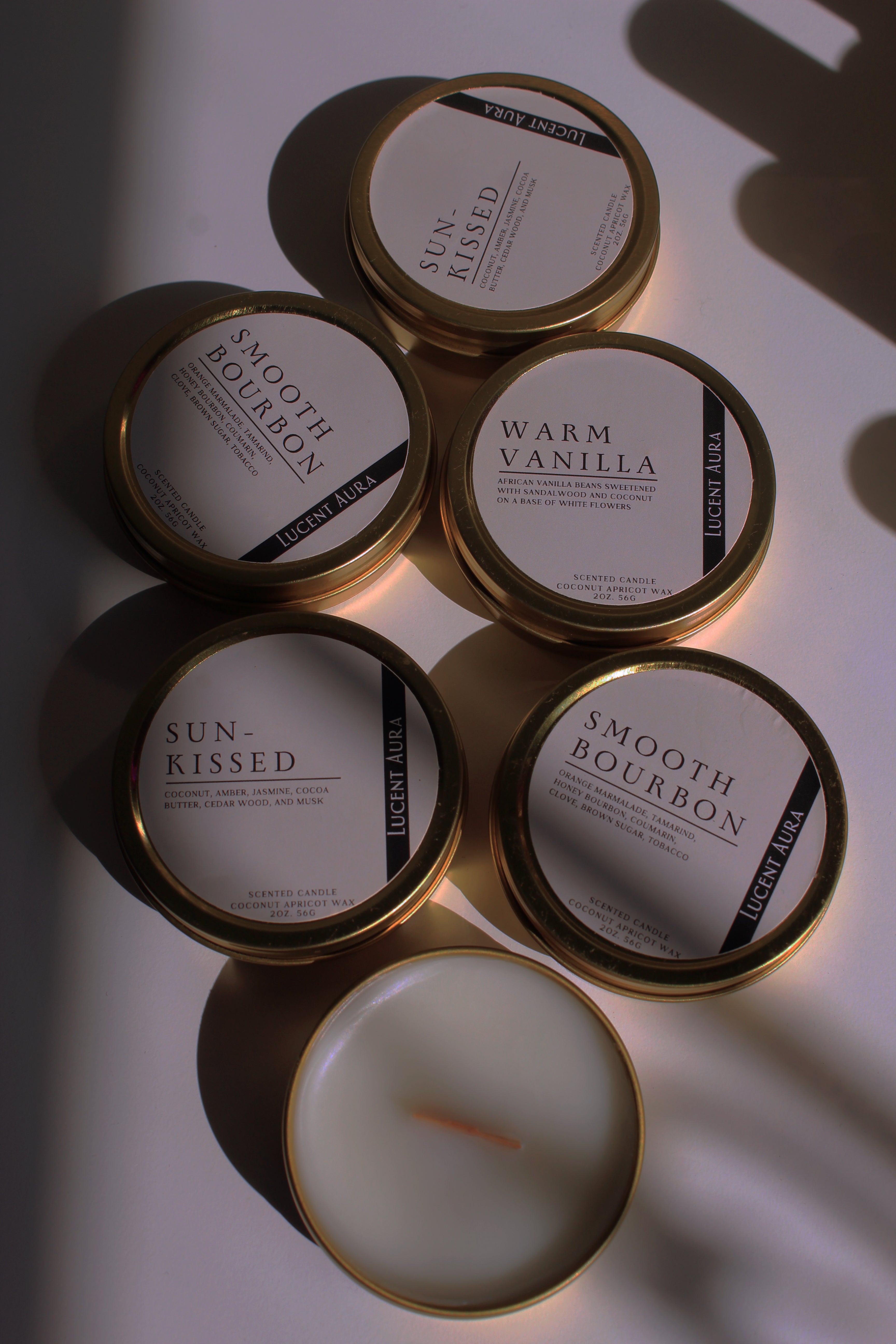 Collection of candles with labeled containers on a reflective surface