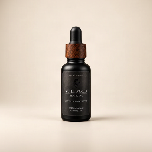 A bottle of Lucent Aura Stillwood Beard Oil with a black dropper cap, a dark wood collar, and a black label, set against a solid beige background.