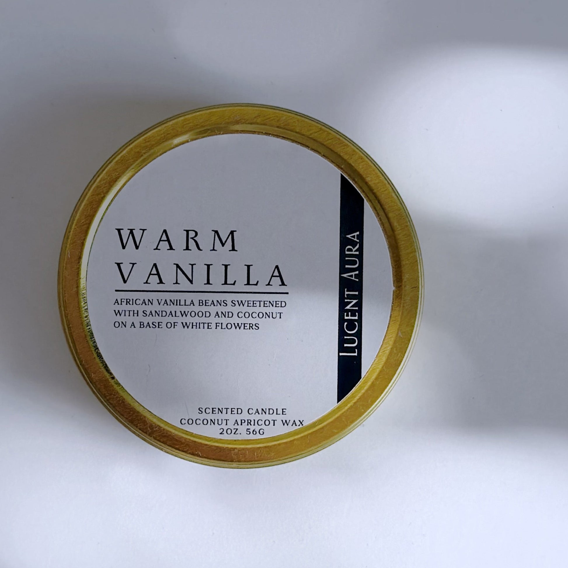 Candle container labeled 'Warm Vanilla' by Lucient Aura on a light background