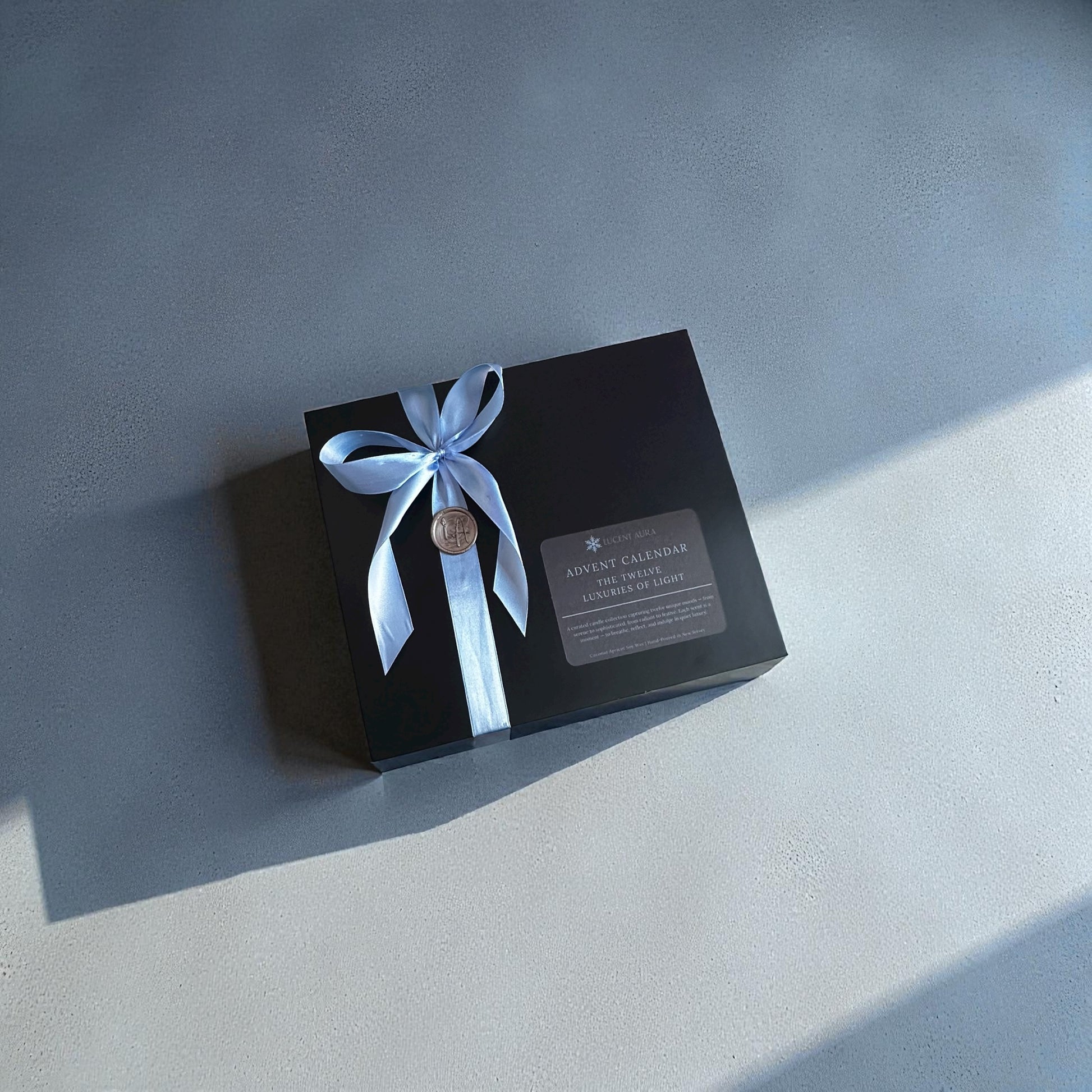 Lucent Aura advent calendar gift box wrapped with a blue ribbon.