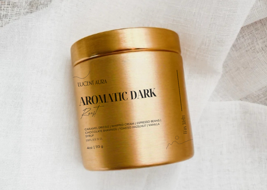 Gold container of Lucent Aura Aromatic Dark roast coffee on a light fabric background
